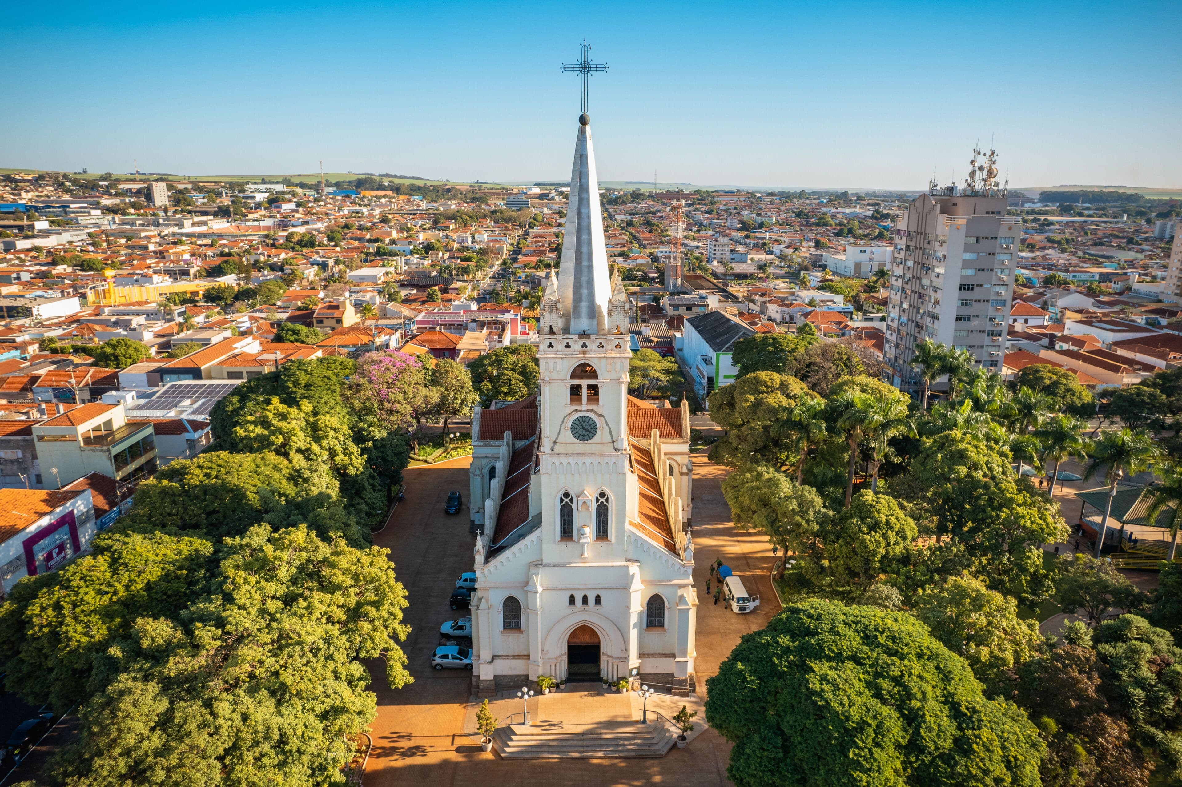 Vista aérea de uma cidade do interior, com igreja histórica e ruas arborizadas